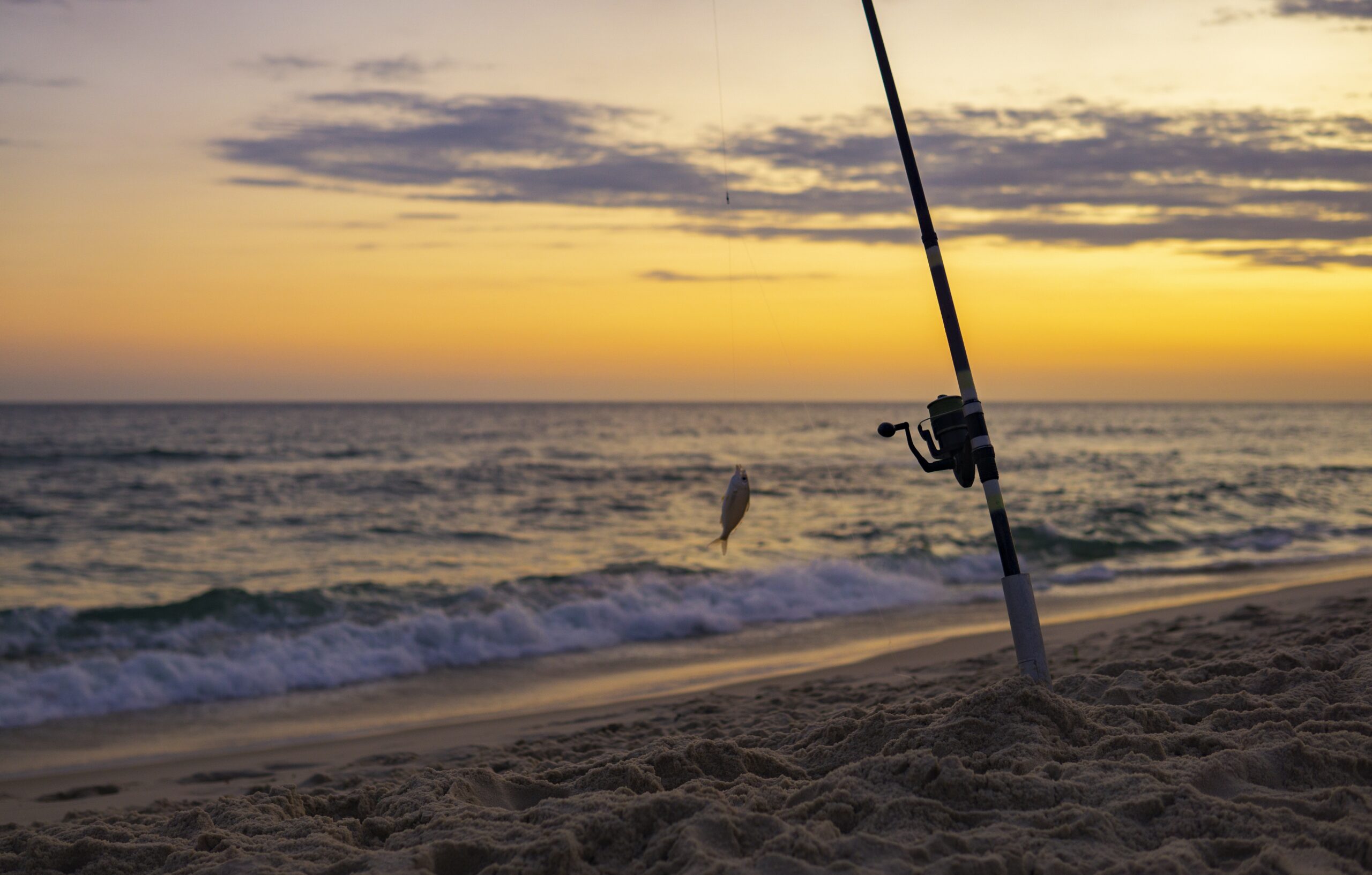 Surf fishing rod in the sand at sunset along the North Carolina coast